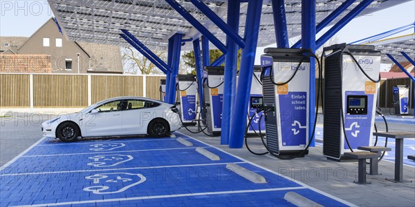 Electric vehicle being refuelled at charging station