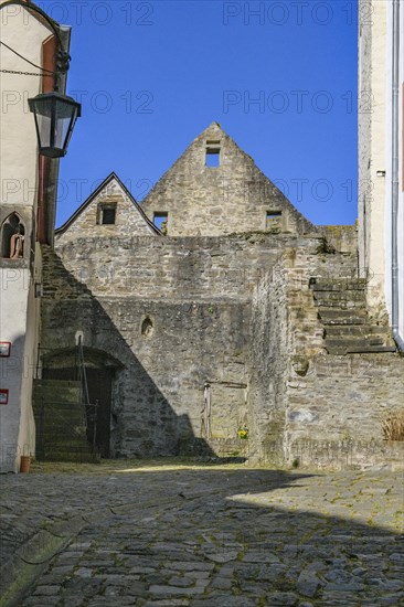 View from castle courtyard of Trier castle to ruin of Cologne castle in double castle Buerresheim from Middle Ages