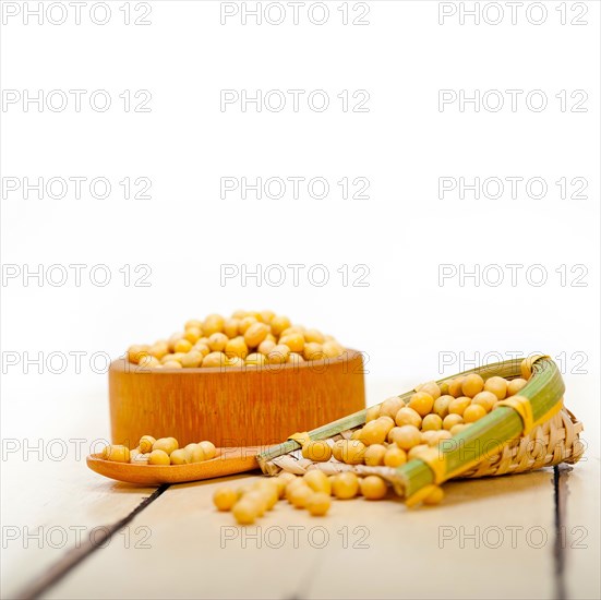 Organic soya beans over rustic wood table macro closeup