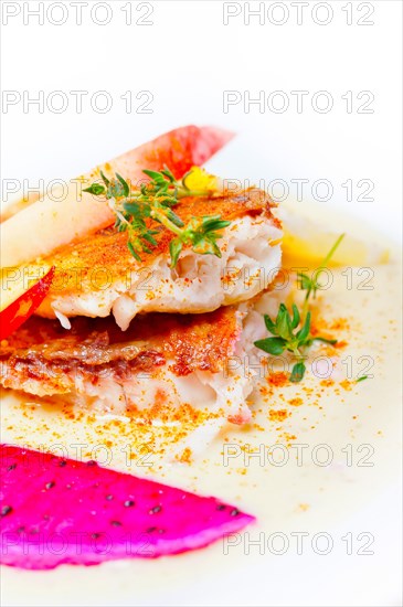 Sea bream orata fillet butter pan fried with fresh peach prune and dragonfruit slices thyme on top