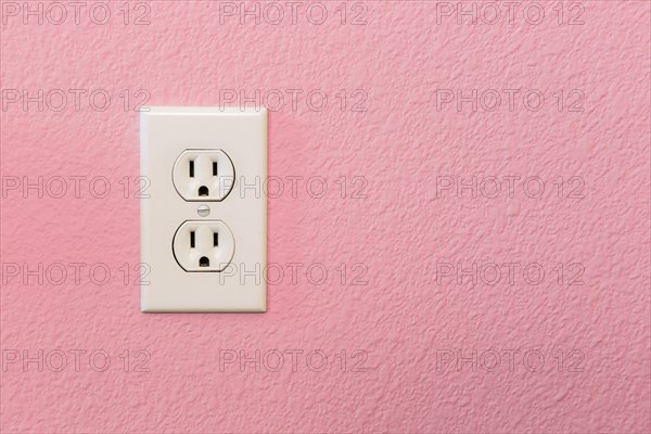 Electrical sockets in colorful pink wall of house