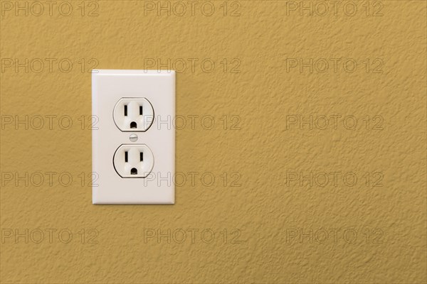 Electrical sockets in colorful mustard yellow wall of house