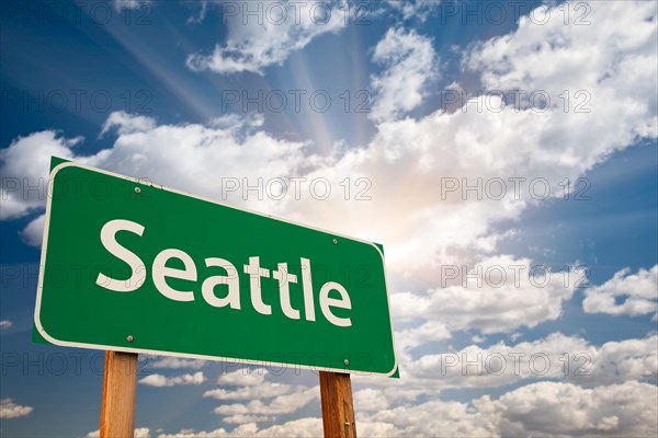 Seattle green road sign over dramatic clouds and sky