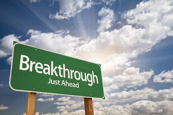 Breakthrough green road sign with dramatic clouds and sky