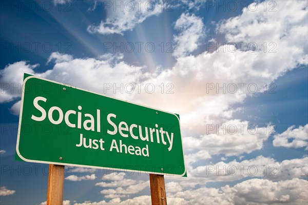 Social security green road sign over dramatic clouds and sky