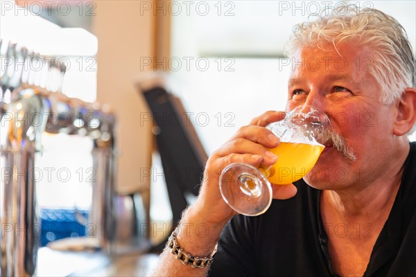 Handsome man tasting A glass of micro brew beer