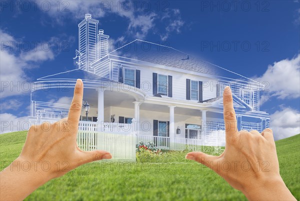 Female hands framing beautiful custom house drawing and ghosted house above grass field