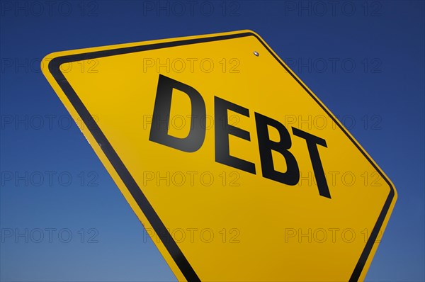 Yellow debt road sign on a deep blue sky background with clipping path