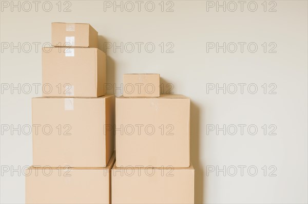 Variety of packed moving boxes in empty room against wall