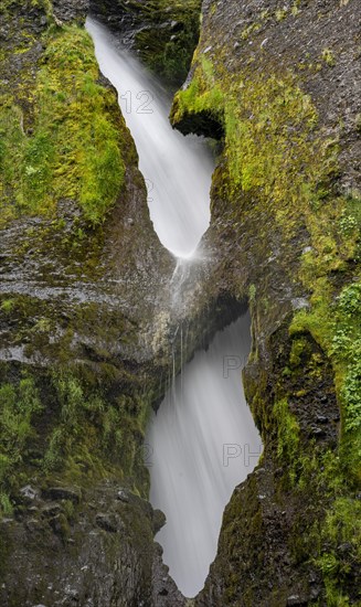 Waterfall behind two rock holes