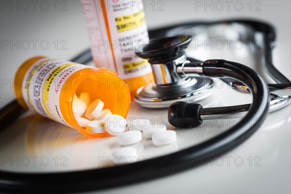 Non-Proprietary medicine prescription bottles and spilled pills abstract with stethoscope