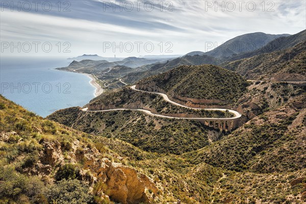 View from La Granatilla viewpoint of winding coastal road and viaduct in hilly landscape. Cabo de Gata Nijar nature Park