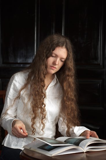 Young beautiful woman with long hairsreading a book