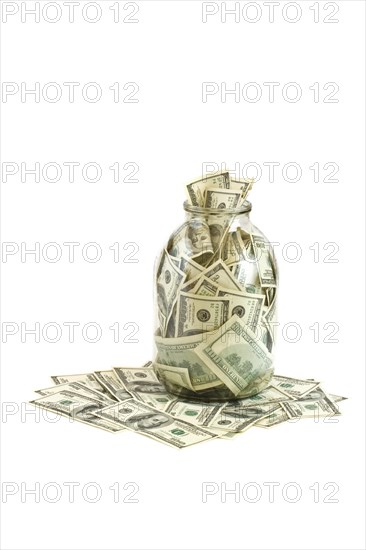 Glass jar full of hundreds of dollars isolated on white background