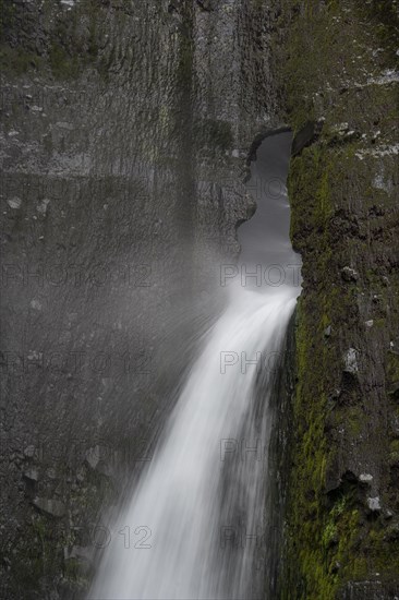 Waterfall flowing through small rock hole
