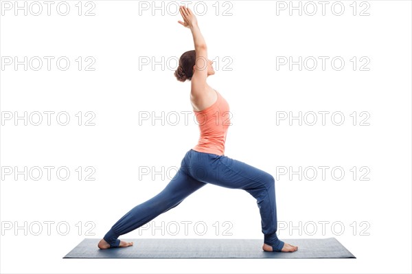 Beautiful sporty fit yogini woman practices yoga asana Virabhadrasana 1