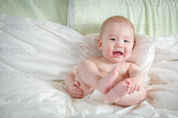 Young mixed-race chinese and caucasian baby boy having fun on his blanket