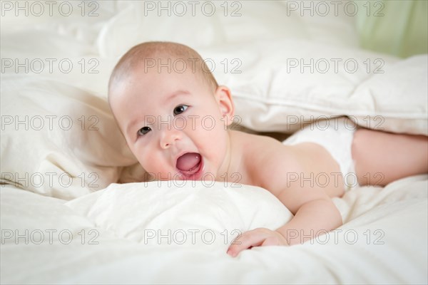 Young mixed-race chinese and caucasian baby boy having fun on his blanket