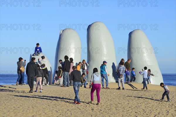 Tourists in front of the sculpture La Mano