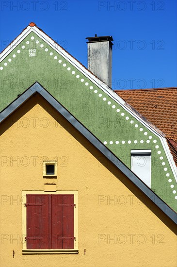 Orange Fassade und Dach mit Bieberschwanzziegeln