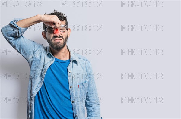 A person with nasal bridge pain. Man with nasal bridge headache