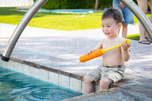 Young mixed-race chinese and caucasian boy playing at the pool