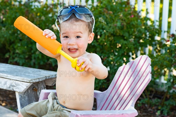 Happy playful young mixed-race chinese and caucasian boy wearing swimming goggles