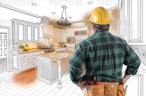 Male contractor with hard hat and tool belt looking at custom kitchen drawing photo combination on white