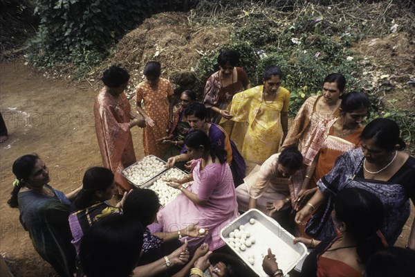 Kodava women making rice ball Kadamputtu