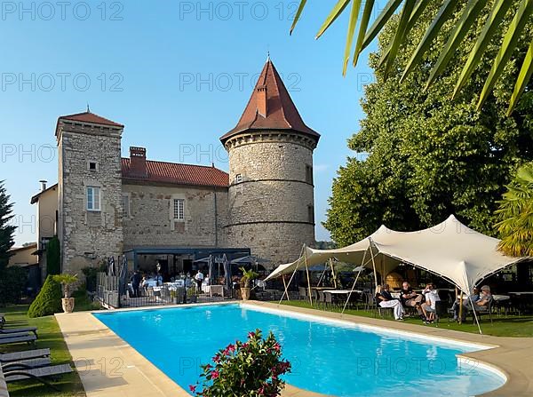 View over swimming pool to castle tower Tower of Chateau de Chapeau Cornu