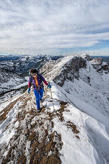 Climber on a rocky snowy ridge, hiking trail to Ammergauer Hochplatte