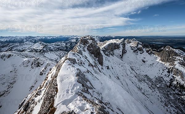 Rocky snow-covered mountain ridge of the Ammergauer Hochplatte, behind peak Kraehe