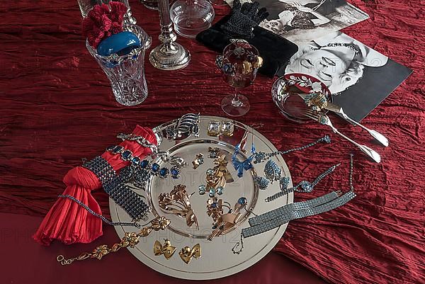 Rhinestone jewellery and accessories decorated on a silver plate and red cloth, Bavaria