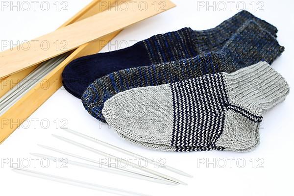 Self-knitted socks made of wool isolated against a white background. In different colours and sizes,