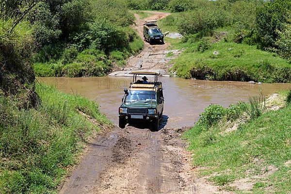 Safari jeep driving through river, Masai Mara National Reserve