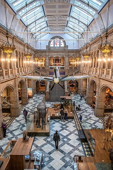 An airplane hanging in the lobby of the Kelvingrove Museum with stuffed animals in Glasgow, Scotland