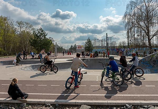 Skateboarders and cyclists at a skate pool in the Park am Gleisdreieck in Berlin-Mitte, Berlin