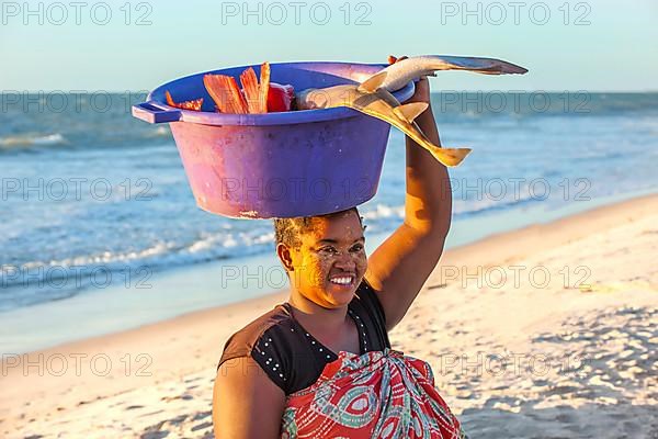 Malagasy woman carrying fish in a bowl on her head