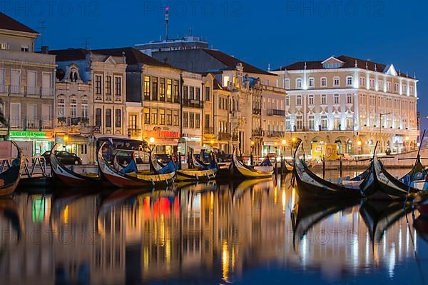 Gondola-like Moliceiros boats anchored at night on the Central Canal