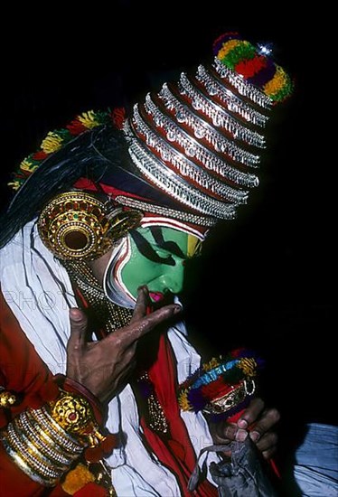 A Katakali artist applying makeup