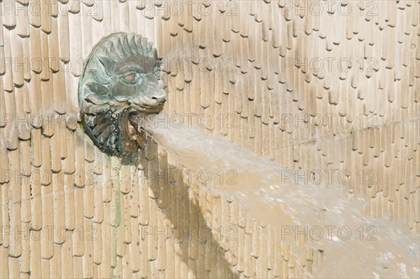 Lion's head ornamental fountain in city churchyard