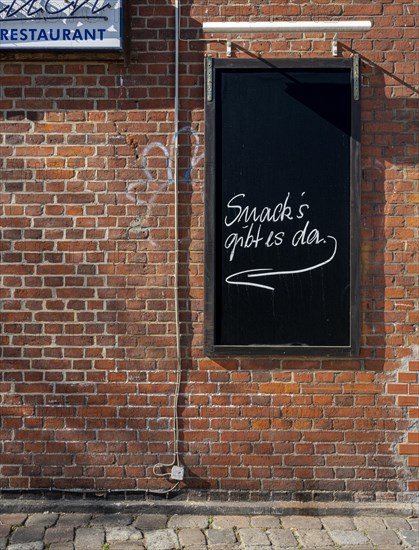 Slate plaque on the brick wall of a restaurant