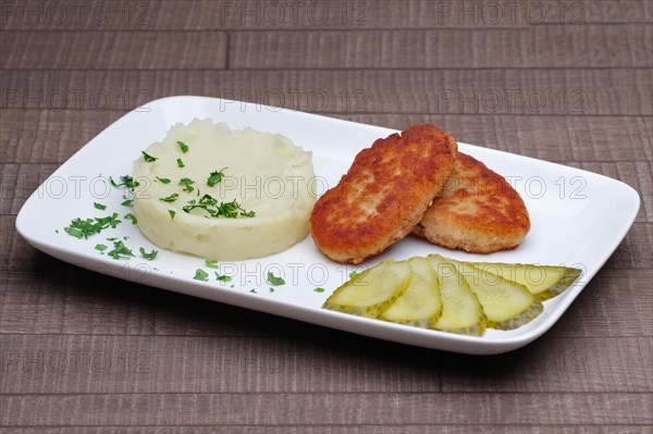 Cutlet with mashed potato and pickled cucumber