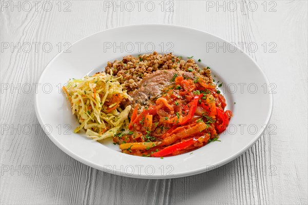 Plate with chopped meat backed with bell pepper with buckwheat and cabbage salad