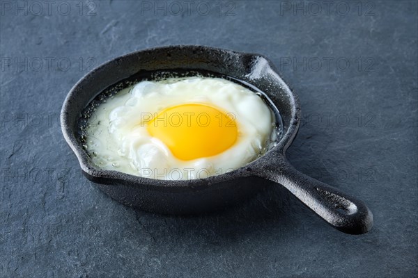 Scrambled egg in small cast-iron skillet. Making omelet eggs