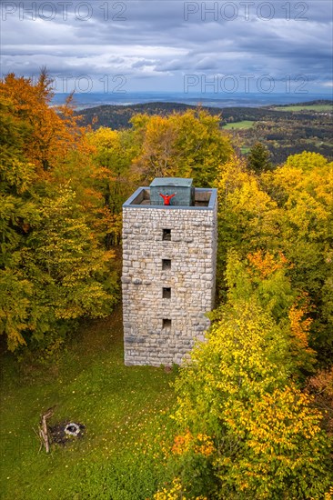 Man in red on tower in autumn forest