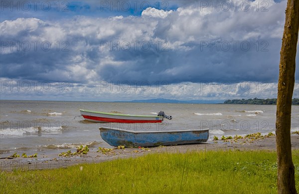 Two fishing boats parked on the shore of a lake