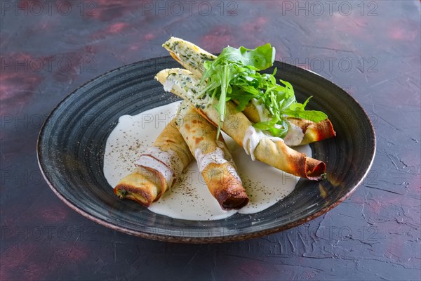 Thin pancakes stuffed with arugula and cheese