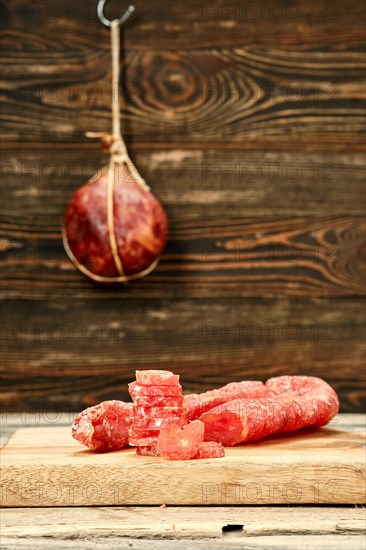 Smoked dried turkey sausage cut on slices on wooden cutting board