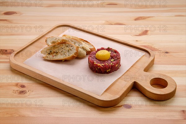 Classic steak tartare with egg and garlic bread